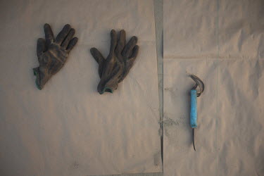 Blas Orozco (47) gloves and knife for harvesting grapes. The crop will be used to make raisins, the harvest is called 'la tabla', referring to the piece of paper where they place them. They get paid d...