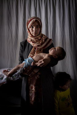 Hojatullah (11 months old) with his mother Afi sa (25) (left) are seen by a health worker in a small clinic managed by UNICEF. Children from the village of Alibeg and surrounding area are being medica...