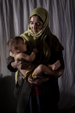 Nafisa (35) with her son Hadi (10 months), who has been diagnosed as moderately malnourished. They are being seen by a health worker in a small clinic managed by UNICEF. Children from the village of A...