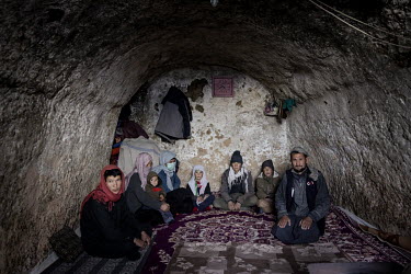 Ayz Ali (left) and Sabera (pink scarf) and their six children who are living inside this cave near the city of Bamiyan. The family arrived as refugees to the city 18 years ago and as they couldn't aff...