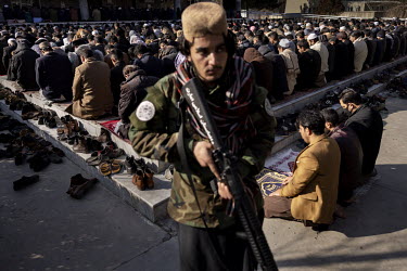 Sohalullah Hajrat (19) keeps guard during at Friday prayers at a mosque in central Kabul, protecting it from attacks of any kind. Hajrat has been with the Taliban for about three years since he was 16...