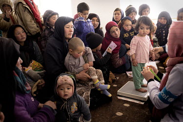 Women waiting, with their children, for their turn to see a health worker from an UNICEF mobile team visiting the village of Mirane Rostam, a day's travel from the city of Bamiyan. UNICEF is there to...