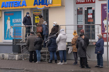People queue outside a pharmacy.