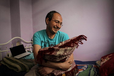 Mojtaba (27), from Iran, cuddling a cushion on his bed. Mojtaba explains that he feels lonely in Turkey where he was claiming asylum in a third country. Mojtaba identifies himself as a gay man, and sa...