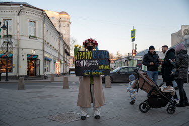 A woman wearing a flower garland (vinok) and holding an anti-war sign, written in the colours of the Ukrainian flag, makes a 'single picket' protest against the invasion of Ukraine.
