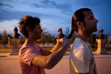 Navid (R, 27), and Sourena (L) tying his hair in a park in Isparta.  Navid left Iran for Turkey to claim asylum in a third country through the UNHCR. He believes that Iran isn't ready for homosexualit...