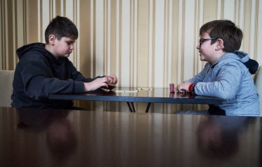 Roma, from Lysychansk, a town located (before the Russian invasion) about 30 kilometres from the frontline plays domino with Zakhar, a son of a lady who works in a hotel, where Roma settled after thei...