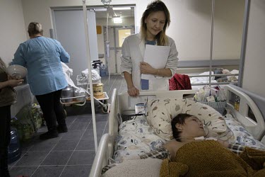 Dr Rusyn Anastia examines a young child during her wards rounds at the Okhmadyt Children's Hospital. Lots of children and their families are stuck in Kyiv as they are dependent on continuous medical c...