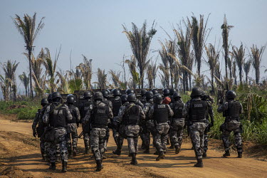 Riot police walk down a dirt road inside the Bom Futuro National Forest to remove invaders who had set up a camp with about 200 shacks inside the reserve. In 2019, Bom Futuro lost 874 hectares of fore...