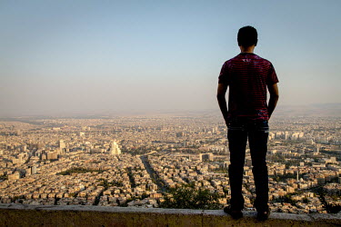 Bissam, a gay man from Baghdad, Iraq stands on a hillside overlooking Syria's capital Damascus. Forced to flee Iraq, Bissam spent almost five years in Syria as a refugee before moving to Turkey for a...