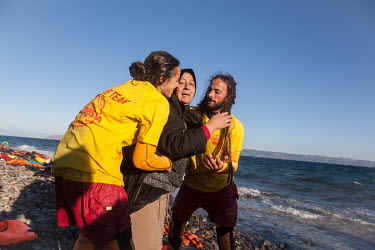 An Iraqi woman is helped to safety by Spanish volunteer lifeguards, after arriving on the Greek island of Lesvos.
