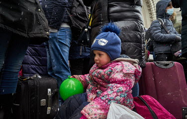 A child holds the balloon while waiting, as the snow falls, with her parents for hours among a huge crowd outside the station for the humanitarian train to Lviv. Most of the people are from Dnipro whi...