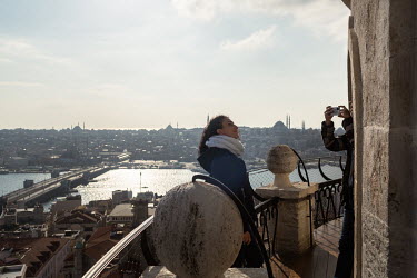 A foreign tourist poses for photographs on the Galata Tower during a nationwide weekend coronavirus curfew which didn't apply to overseas visitors.