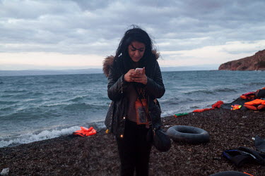 A refugee sends messages after arriving in a small boat from Turkey.