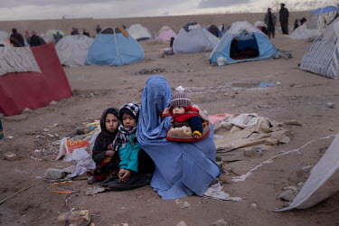 Single mother Qamar Gul, her son Said (5 months) and her two daughters Sumaya (9) and Mariam (7) huddle in the open in a makeshift camp.   About one thousand people have moved from their villages and...
