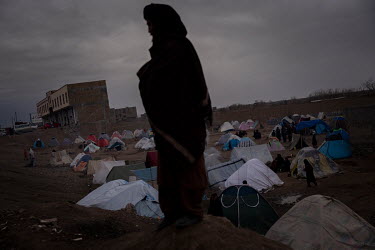 A man stands above the tents in a makeshift camp where about one thousand people have moved, and are now living in subhuman conditions, from their villages and farms in the countryside due to the food...