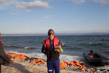 A man celebrates on a beach near Molyvos after just arriving from Turkey on a rubber dinghy.