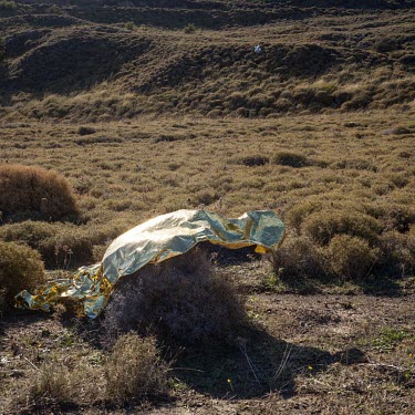 A discarded space blanket used by informal migrants who recently smuggled themselves across the Aegean Sea from mainland Turkey to Greece.