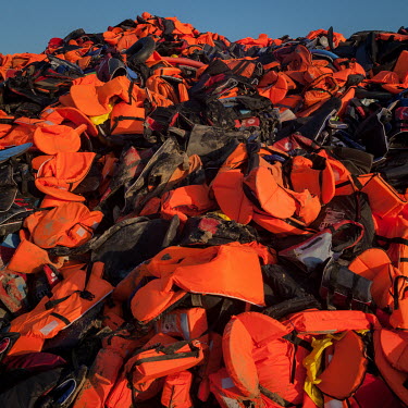 A large pile of discarded life vests used by informal migrants who recently smuggled themselves across the Aegean Sea from mainland Turkey to Greece, collected from the beaches of Lesvos.