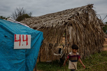 A boy walks past shacks in the in Vila Rio Pardo encampment. The camp was set up last year by landless families who were removed from an area of land illegally invaded inside the Bom Futuro National F...
