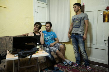 Arash (left) and Arsham (centre) at home with friends. The men left Iran and claimed asylum in a third country through the UNHCR, from Turkey, on grounds of their homosexuality, which is illegal in Ir...