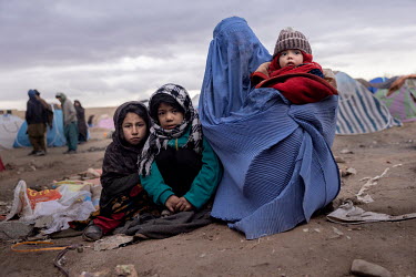 Single mother Qamar Gul, her son Said (5 months) and her two daughters Sumaya (9) and Mariam (7) huddle in the open in a makeshift camp. About one thousand people have moved from their villages and fa...