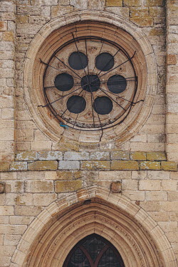 Wire mesh and metal bars protect a circular rose window on the exterior of the Iglesia de Santa Maria del Castillo, a 13th century Romanesque church in the village of Castronuno.