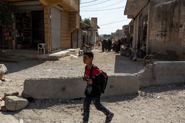 A schoolboy walks through the damaged streets of Tel Abyad which has come under the control of various rival groups since the start of the conflict in 2011. From the Syrian regime, to Kurdish forces,...
