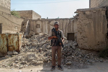 A Syrian opposition soldier stands guard on a street in central Tel Abyad, which is within the Operation Peace Spring zone, overseen by Turkey's military and governed by local Syrians.