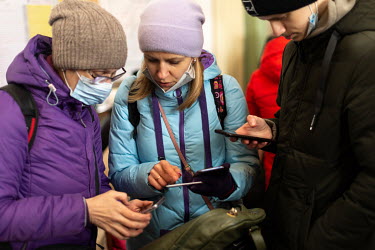 Ukrainian refugees look at their phones at Przemsl Glowny train station, 15 kms from the Polish Ukrainian border. Ten days after the start of the Russian war with Ukraine, thousands of refugees pass t...