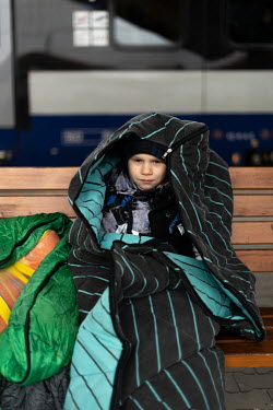 A young Ukrainian refugee wrapped up in a sleeping bag against the cold at Przemsl Glowny train station, 15 kms from the Polish Ukrainian border. Ten days after the start of the Russian war with Ukrai...