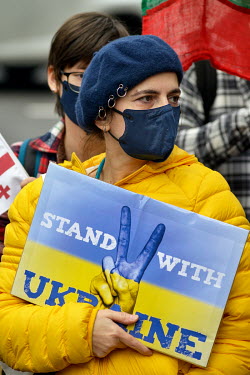 A woman holds a sign that reads: 'stand with Ukraine' at a pro-Ukraine rally held outside the Russian representative office following the news that overnight president Putin had ordered a full-scale i...
