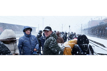 Ukrainian refugees waiting in the snow on a platform at Suceava's station for a train to take them directly to Bucharest.