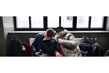 An Ukrainian refugee couple rest in the Suceava train station waiting room.