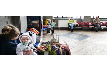 An Ukrainian refugee mother with her child in the Suceava train station waiting room.
