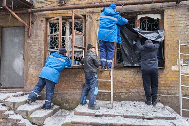 Local residents, with the help of emergencyÂ�workers, boarding up smashed windows in their apartments, a result of a 6am by Russian air strike on a nearby shoe factory. The pressure wave shattered wi...