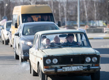People driving in a old Lada car flee to the capital.  White flags and handwritten signs that read: 'children', are displayed on many of the vehicles which are packed with IDPS and are continuously ar...