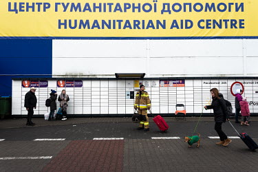 Ukrainian refugees at a humanitarian aid center set up in a disused Tesco's store after crossing the border from Ukraine into Poland.