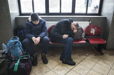 Ukrainian refugees rest in the Suceava train station waiting room.