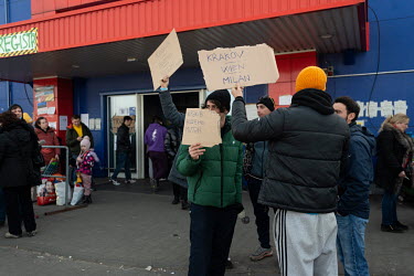 Volunteer drivers hold up signs to various destinatiions in Europe at the Tesco Humanitarian Aid Center for refugees fleeing the war in Ukraine.