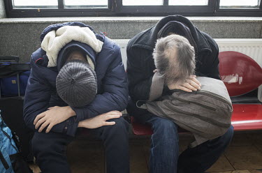 Ukrainian refugees rest in the Suceava train station waiting room.