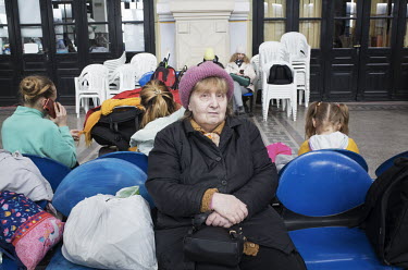 An elderly Ukrainian refugee sits at the Suceava train station waiting room.