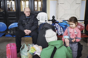 An Ukrainian refugee family in the Suceava train station waiting room.