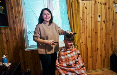 A volunteer cutting Vanya's hair. Vanya (14), along with another 37 children living at the Kharkiv Children's Home, spent a week sheltering from shelling in a cellar before being evacuated to the Eko-...