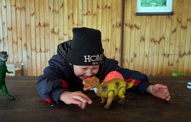 A boy, one of 37 children evacuated a few days earlier from a children's home in Kharkiv, plays with dinosaur toy at the Eko-Hotel Lis Na Samari (Russian Les Na Samari) in Pischanka village.