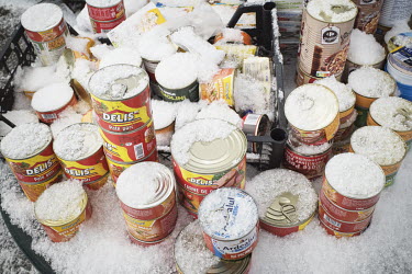 Tinned food covered in snow on a Red Cross distribution stall set up for refugees arriving from Ukraine.