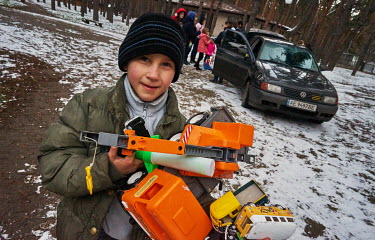 A boy carries an armful of toys donated by locals. He is one of 38 children who were evacuated from the Kharkiv Children's Home, after spending several days in a bomb shelter, to the Eko-Hotel 'Lis Na...