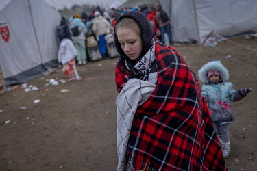 A woman, wrapped in a blanket, with her child in tow near the Krakovetz border crossing point with Poland.