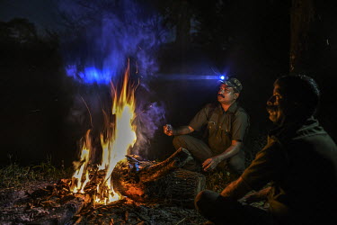 Bijesh T K, 38, surveys the forest with a headtorch during a night duty as a forest watcher. He has survived a tiger attack, sustaining injuries on his hand.
