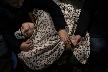 Andrey (6) sleeps, completely exhausted after 24 hours travelling to Lviv and more than a further 14 hours in a queue for a train to Poland. His sister and mother care for him, while his father has st...